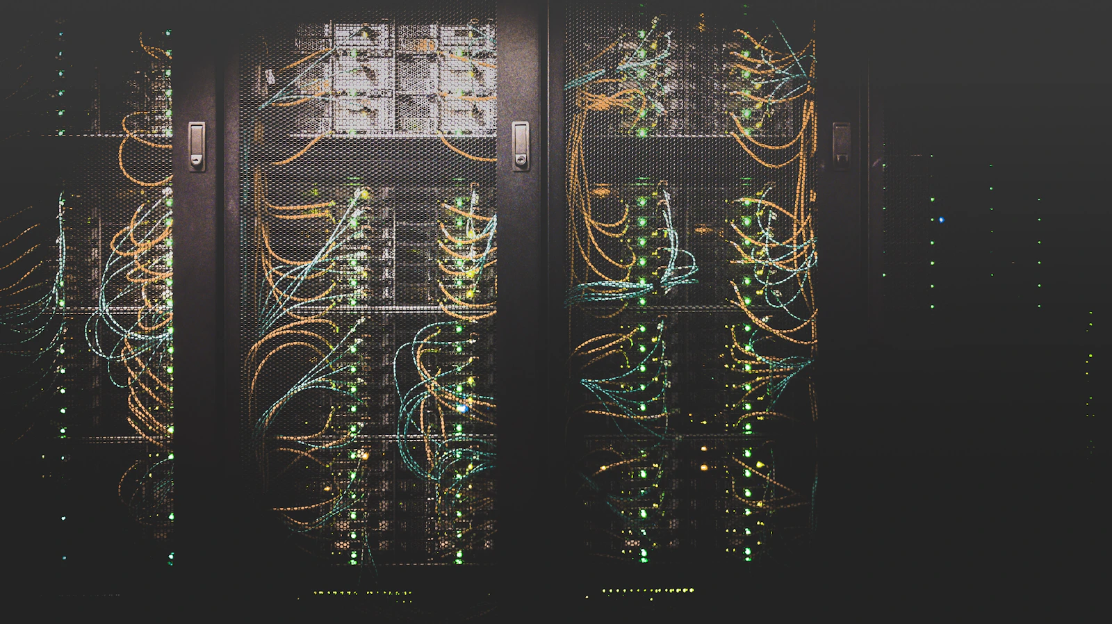 Corredor de data center com fileiras de servidores e cabeamento de rede iluminado